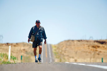A highway mirage encompasses road warrior Justin Yazzie outside Crownpoint on his five-day walk to Farmington on Tuesday. Yazzie is making the long walk for peace and harmony, but also fighting to keep his ranch he leases from the Navajo Nation. &copy; 2011 Gallup Independent / Adron Gardner 